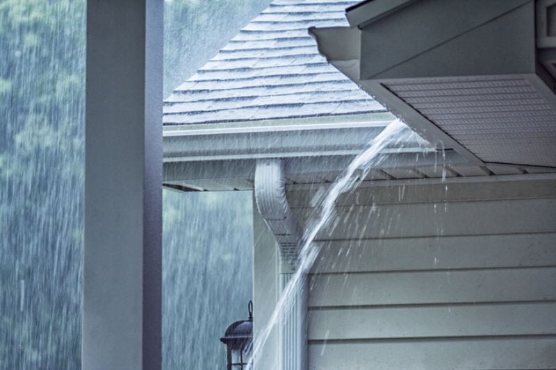 Rain pouring on house to represent information about protecting your AC from storms.