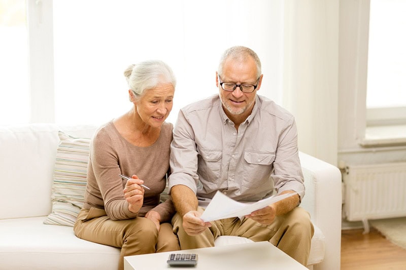 Retired couple reviewing information about why their furnace filter is soggy.