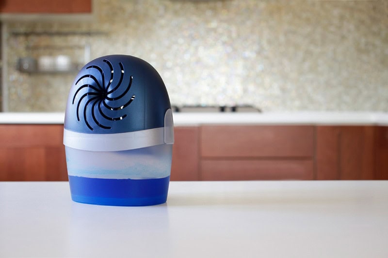 Portable air filter sitting on counter in kitchen.