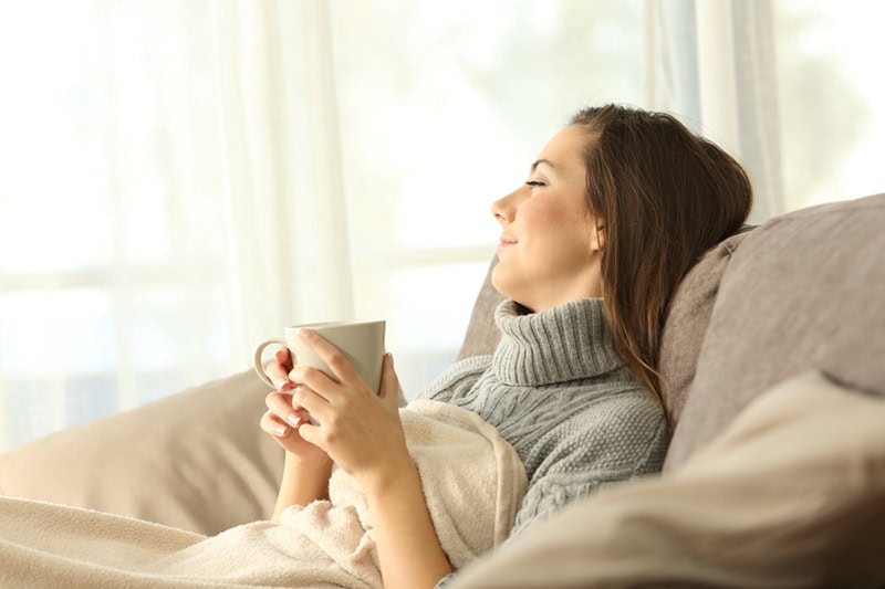Young female homeowner enjoying the comfort of her home after a zone control system install.