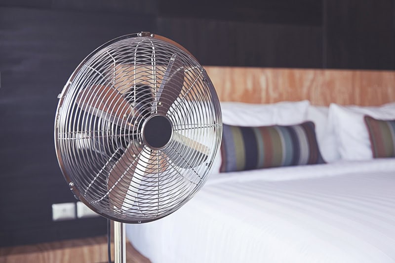Electric fan sitting in bedroom to improve the indoor air quality.