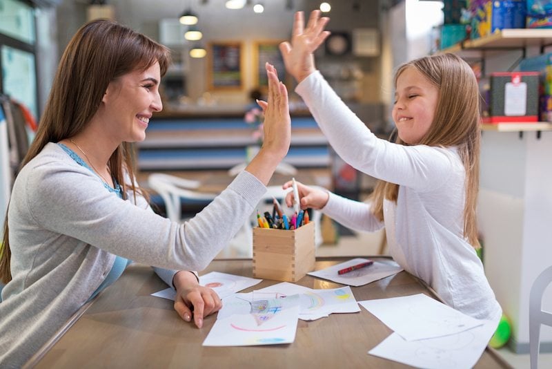 Mother and daughter high-fiving after coloring