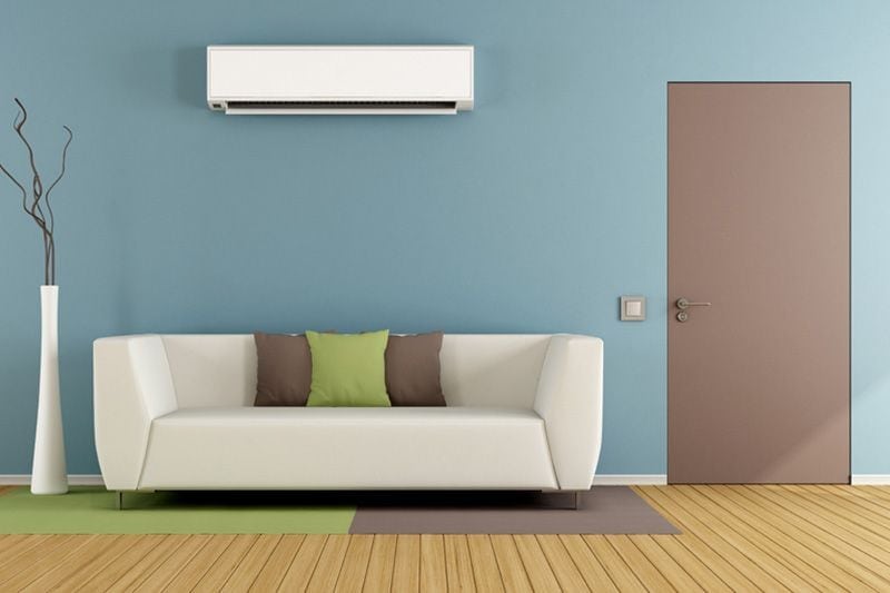 Mounted ductless system on wall in living room.