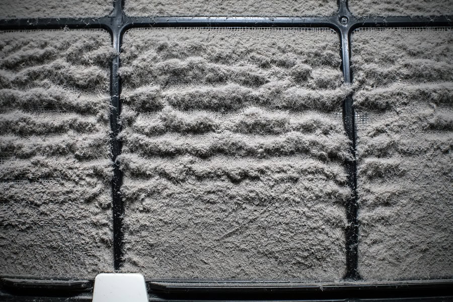 Close up of a dusty home air conditioner filter.