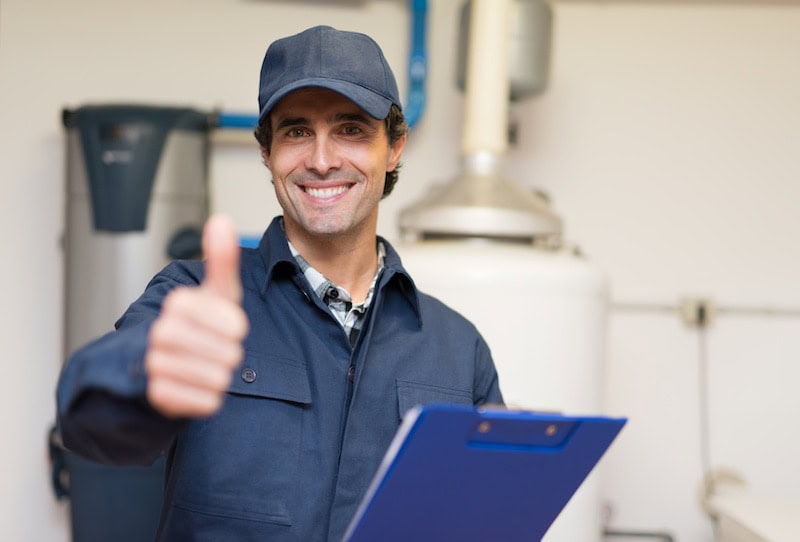 Smiling technician servicing a hot-water heater